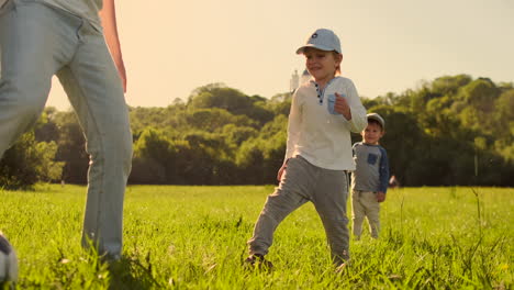 Two-brothers-play-with-a-soccer-ball-laughing-and-smiling-at-sunset-in-the-field.